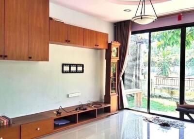 Spacious living room with built-in wooden cabinets and large window view