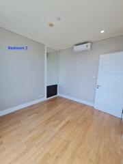 Empty bedroom with wooden floor and air conditioning unit