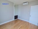 Empty bedroom with wooden floor and air conditioning unit