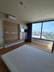 Spacious bedroom with large windows and city view