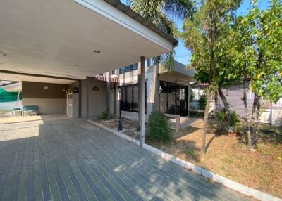 Exterior view of house with covered driveway and greenery