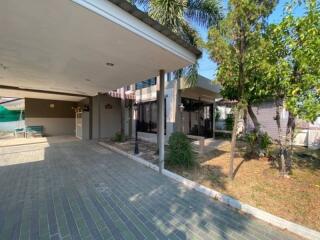 Exterior view of house with covered driveway and greenery