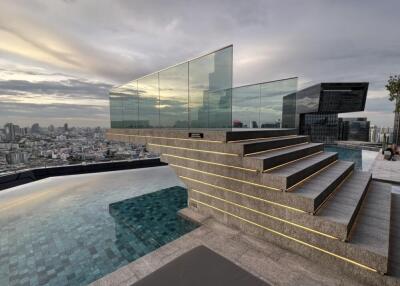 Rooftop pool area with city view and modern glass staircase