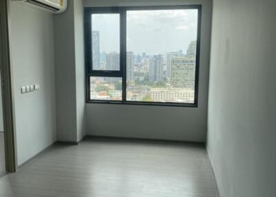 Empty bedroom with large window and city view