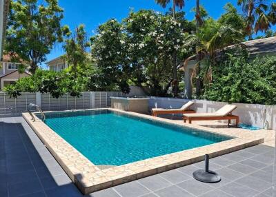 Backyard with swimming pool and lounge chairs