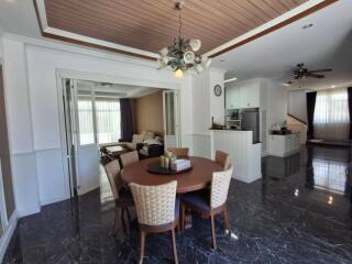 Modern dining room and open living area with wooden ceiling accents and chandelier