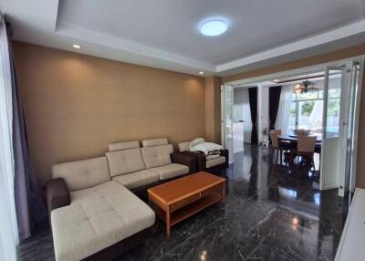 Spacious living room with a beige sectional couch and wooden coffee table