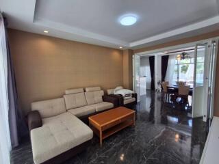 Spacious living room with a beige sectional couch and wooden coffee table