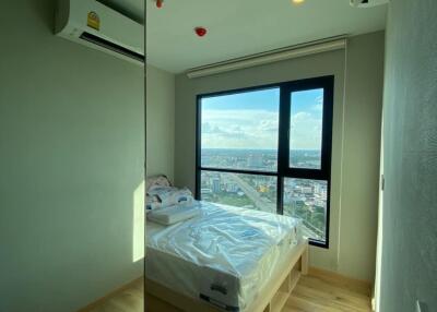 Modern bedroom with large window and wooden flooring