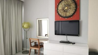 Modern bedroom with wall-mounted TV and decor