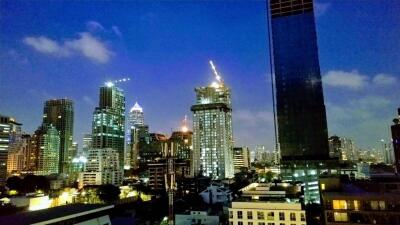 Night view of a city with high-rise buildings under construction