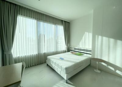 Bright bedroom with large window and minimal furnishings