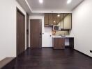 Compact modern kitchen area with dark wood flooring