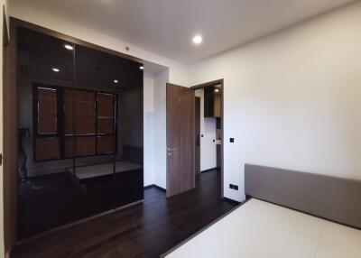 Modern bedroom with mirrored wardrobe and wooden flooring