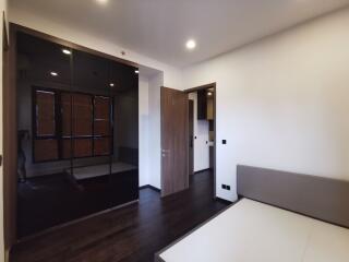 Modern bedroom with mirrored wardrobe and wooden flooring