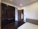 Modern bedroom with mirrored wardrobe and wooden flooring