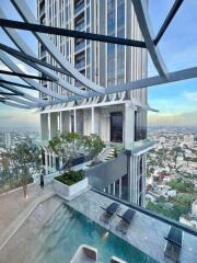 Modern high-rise building with a rooftop pool and city view