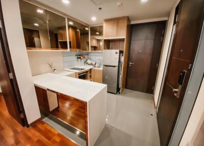 Modern kitchen with a breakfast bar, stainless steel appliances, and wooden cabinetry