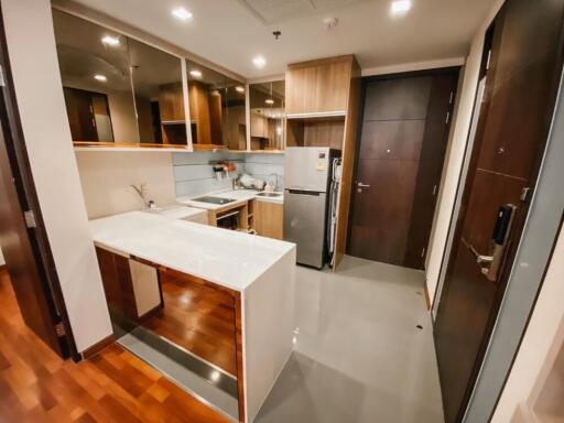 Modern kitchen with a breakfast bar, stainless steel appliances, and wooden cabinetry