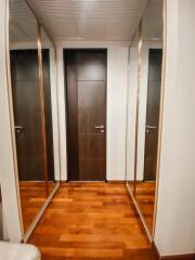 Narrow hallway with wooden doors and mirrored closets