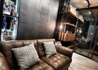 Modern living room with leather sofa, decorative shelves, and ambient lighting