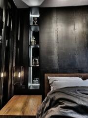 Modern bedroom with a sleek, minimalist design featuring a black accent wall and illuminated shelves.