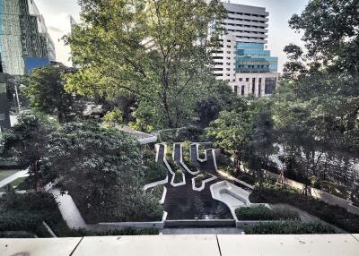 View of the garden area with trees and modern buildings in the background