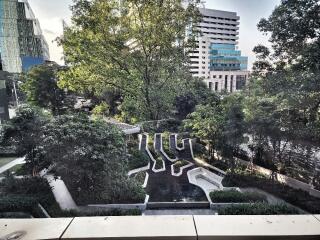 View of the garden area with trees and modern buildings in the background