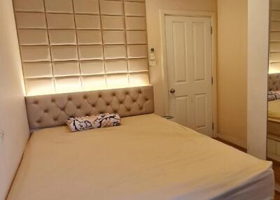 Cozy bedroom with a large bed and built-in closet, featuring ambient lighting and a mirror.