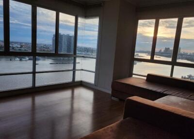 Spacious living room with large windows and a stunning waterfront view