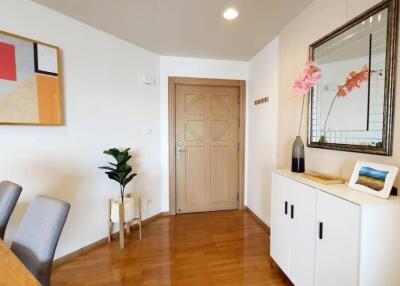 Living room with entrance door, wall art, and cabinet