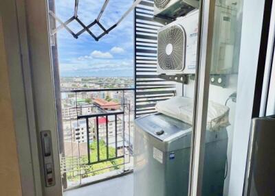 Balcony laundry area with a washing machine and air conditioning units