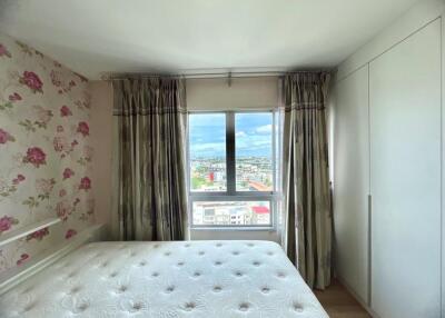 Bright bedroom with a floral wallpaper, bed and large window with a view