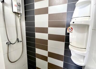 Bathroom with shower area and tiled walls