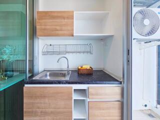 Modern compact kitchen with wooden cabinets and marble countertop