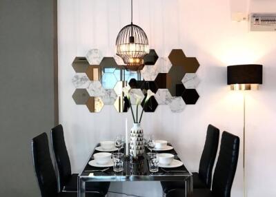 Modern dining area with stylish hexagonal mirror decor and contemporary lighting