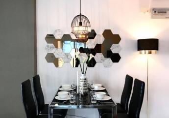 Modern dining area with stylish hexagonal mirror decor and contemporary lighting