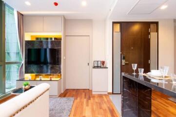 Living room with modern decor, TV, and wooden flooring