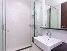 Modern bathroom with glass shower, sink, and mirror