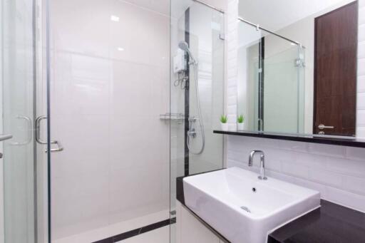 Modern bathroom with glass shower, sink, and mirror