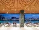 Outdoor pool area with lounge chairs and city view