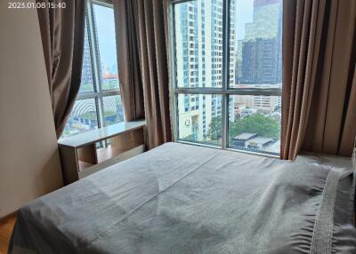 Modern bedroom with large windows and city view