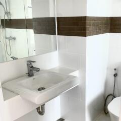 Modern white bathroom with sink and brown-tile accent