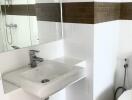 Modern white bathroom with sink and brown-tile accent