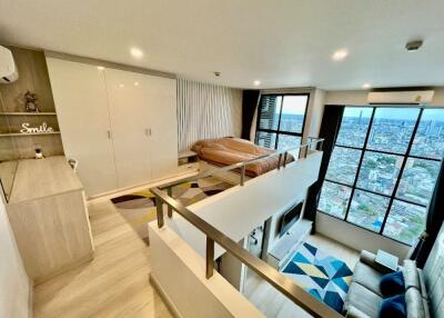 Loft bedroom with large windows and city view