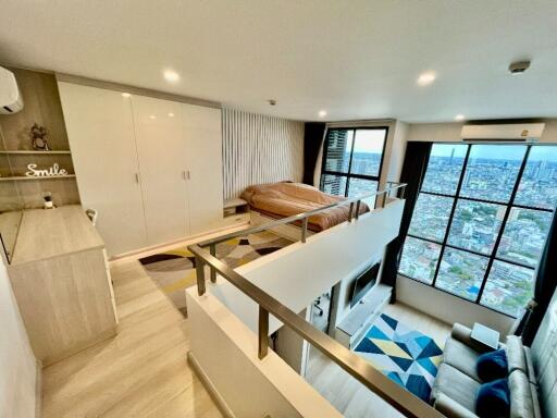 Loft bedroom with large windows and city view