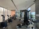 Modern gym with exercise equipment and large windows