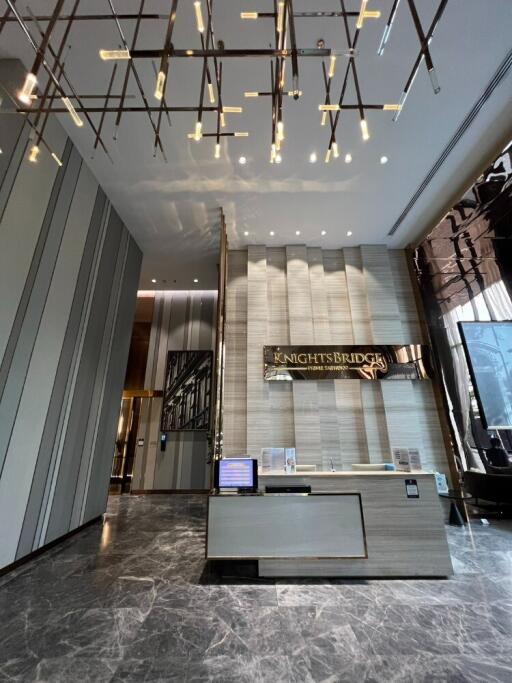 Modern reception area with check-in desk, illuminated ceiling decor, and Knightsbridge nameplate