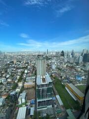 Aerial view of a cityscape with numerous buildings under a clear blue sky