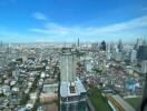 Aerial view of a cityscape with numerous buildings under a clear blue sky